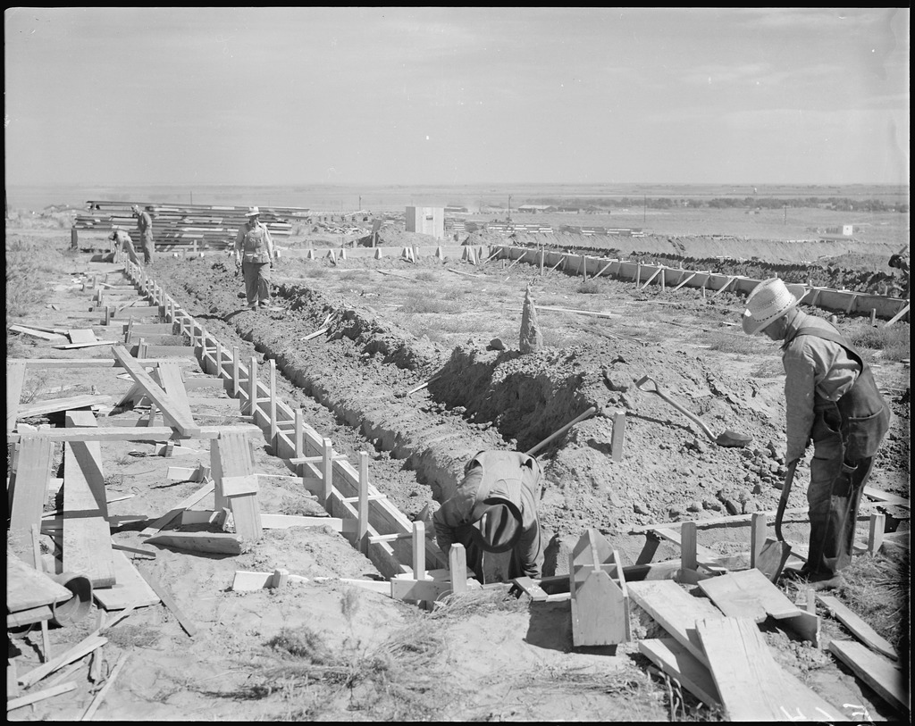Typical scene of the construction of the barracks. Here workmen are laying concrete foundations for a barracks unit. Construction of Granada Relocation Center, Amache, Colorado, 1942