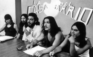 Mexican-Americans protest arrests by police in Denver, Colorado. They are identified as (l to r) Martha Medrano, Esquiel Lovato, Larry Aragon, Antonio Martinez, and Larry Lovato. Lettering reads; "La Casa Del Barrio."